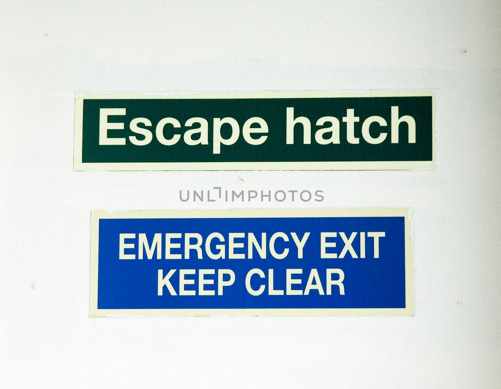 Escape and emergency exit signs on white wall