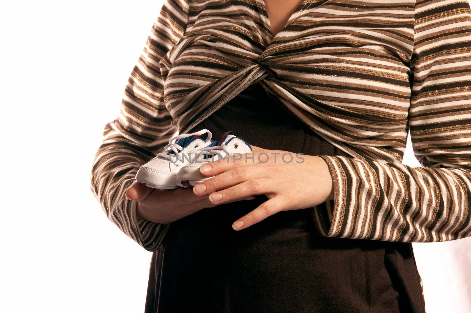 The pregnant woman on a white background. In hands holds small boots