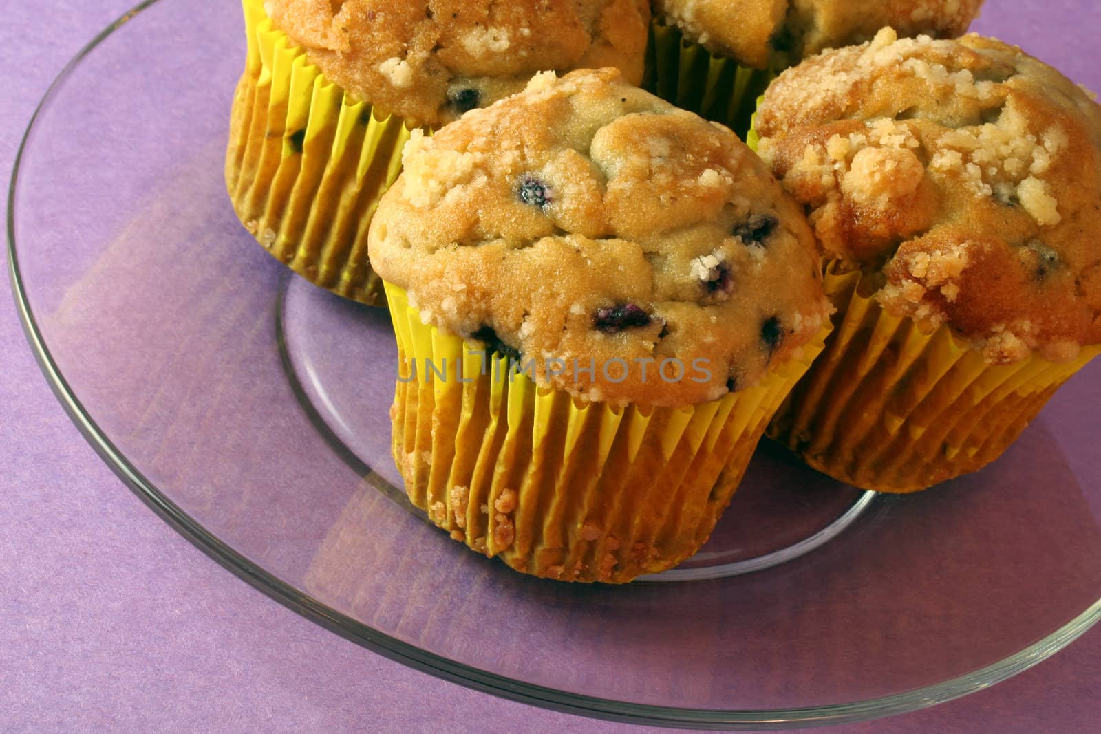 Blueberry muffins on glass plate.