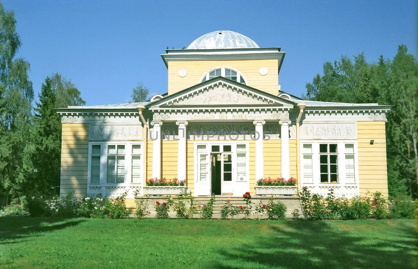 Classical wooden building in front with roses