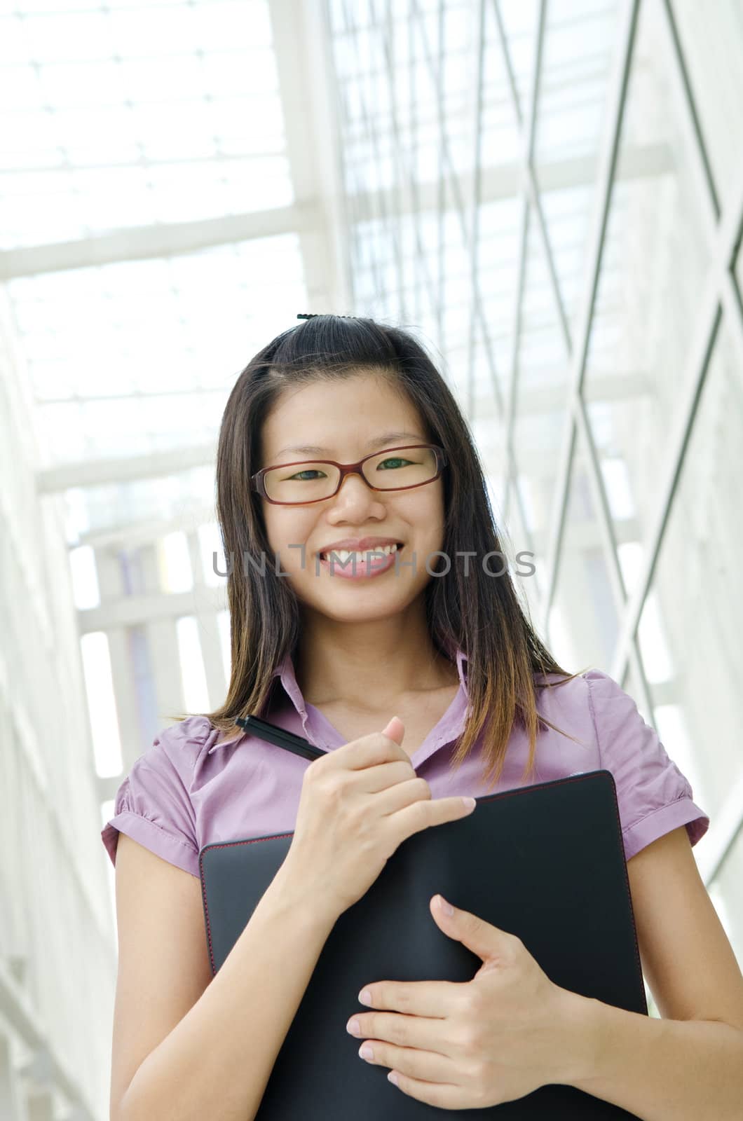 Young Asian Executive with diary, office environment.