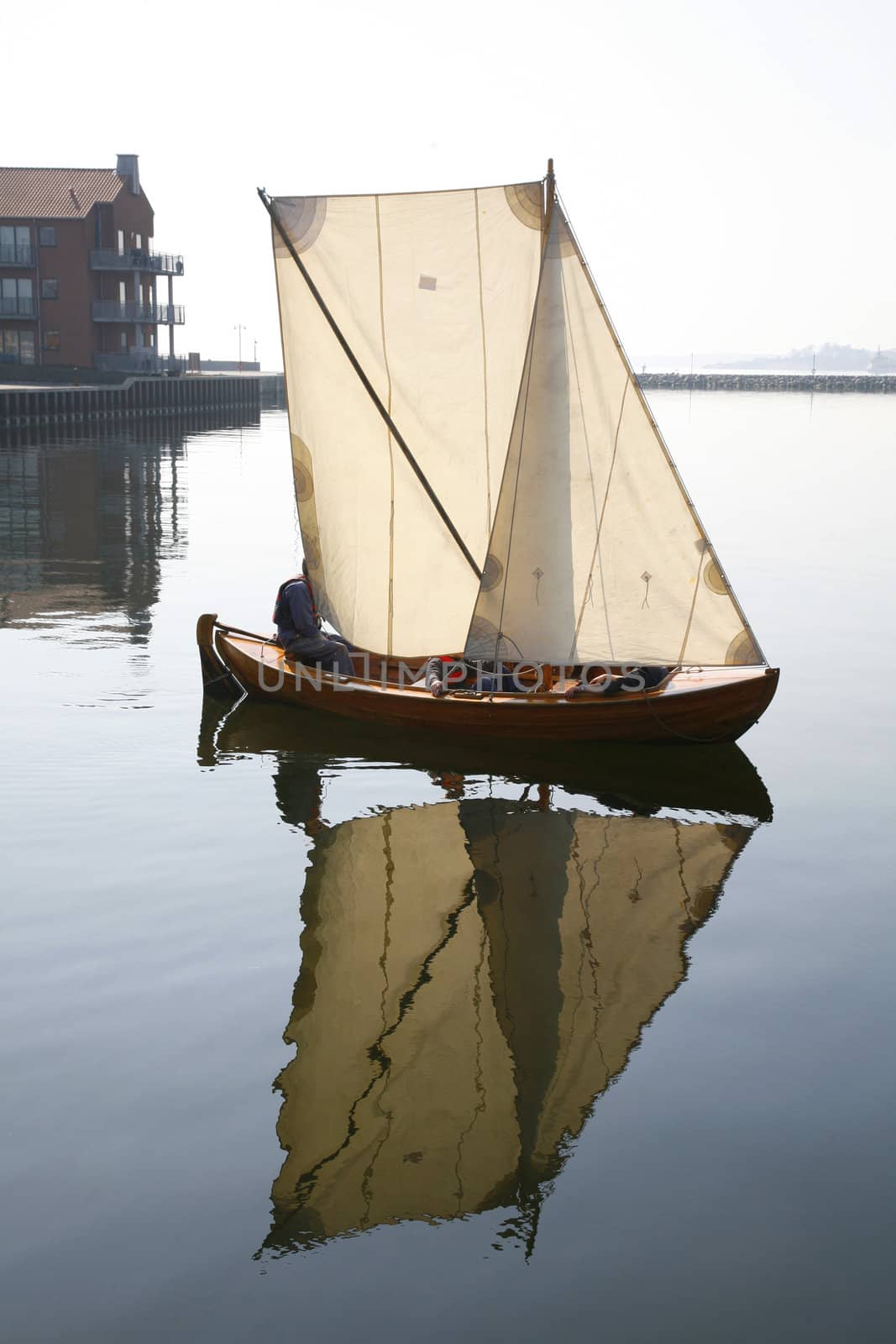 Dinghy in morning mist and very little wind. Western harbour of Nyborg, Denmark.