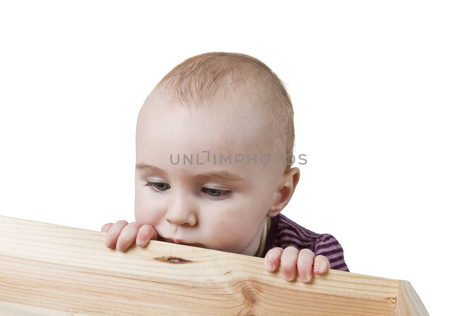 baby looking into wooden box. isolated on white background