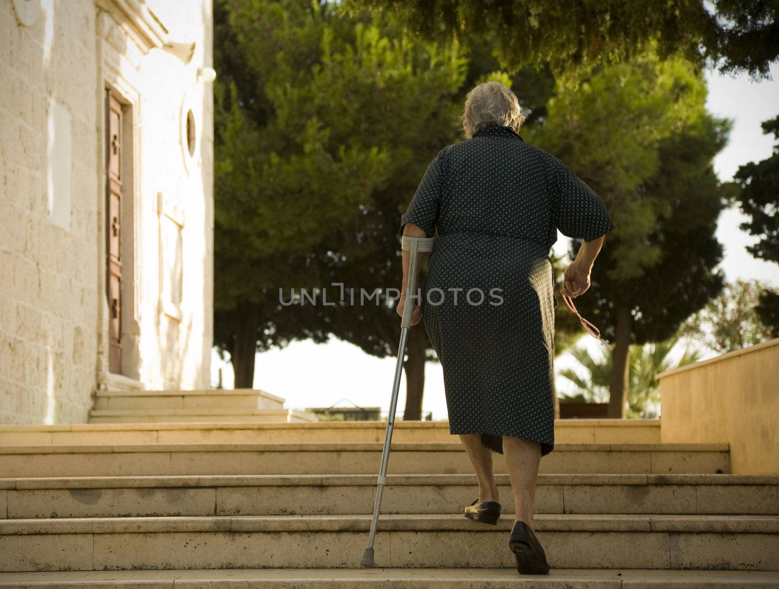 Elderly female on her way to evening Mass - Primosten, Croatia.