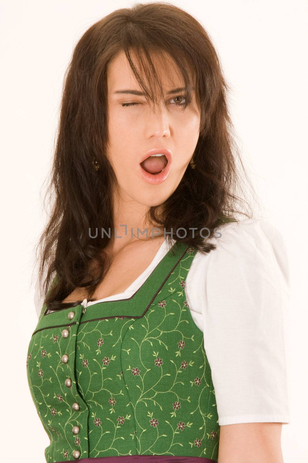 Emotional young Bavarian woman winking with one eye