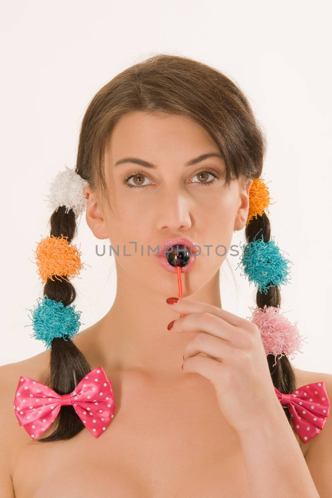 Girl with colorful braids licking a lollipop