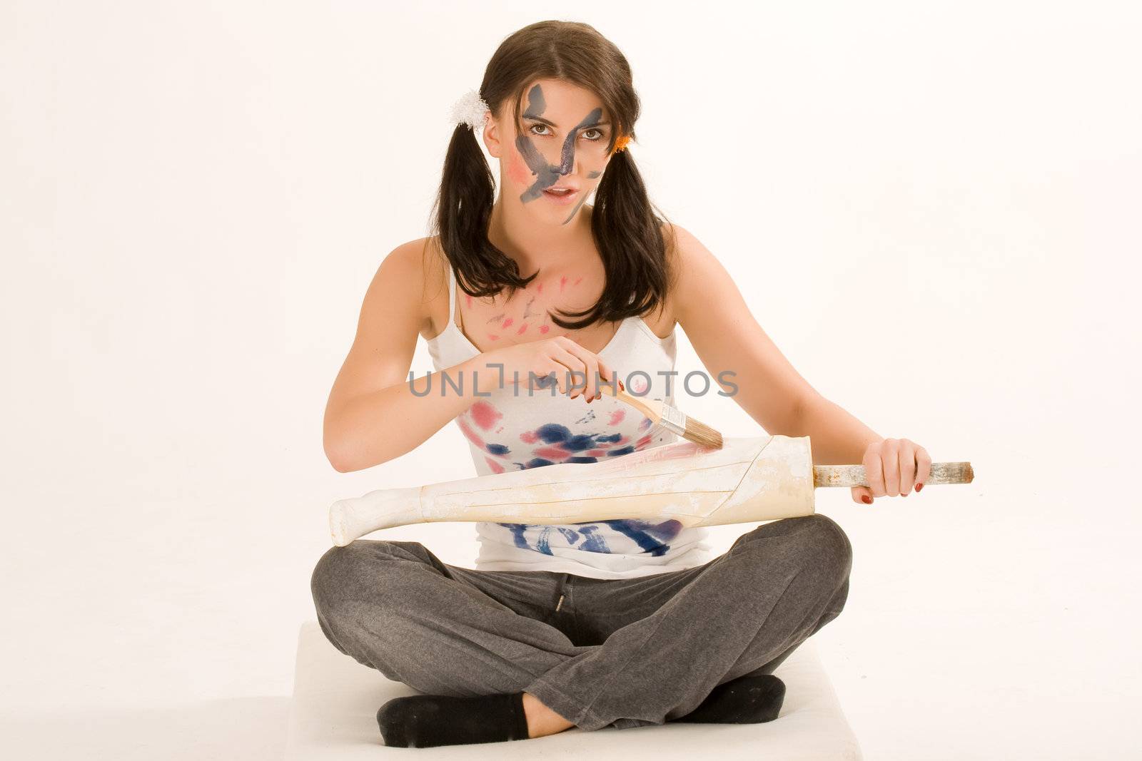 Young woman painting with paint on his face and hands