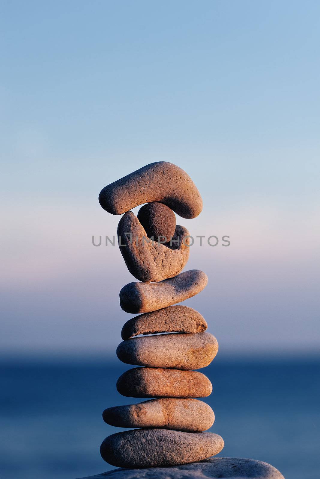 Pile of long pebbles in the balance on the seacoast