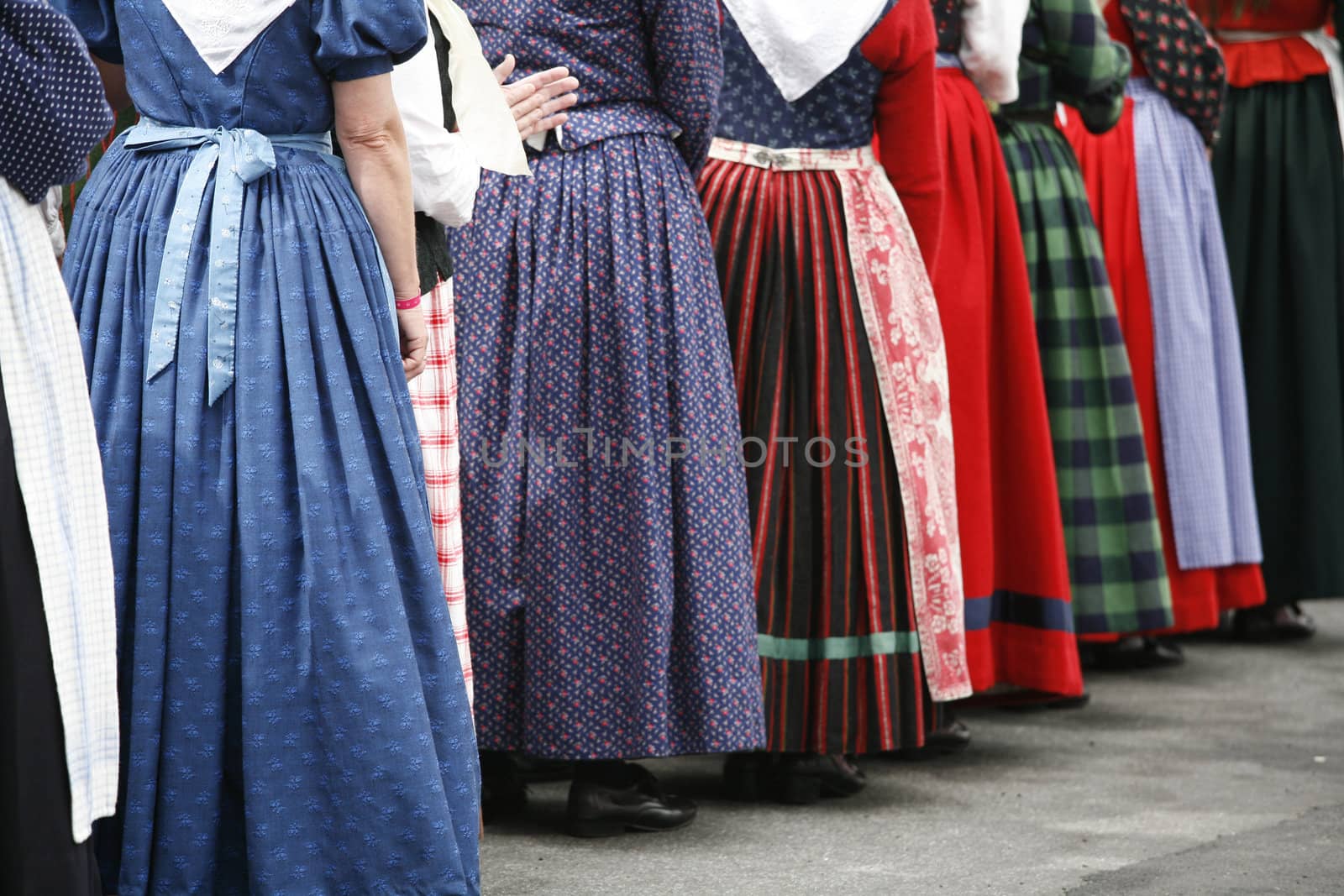 Group of folk dancer women in their colorful old dresses. Shallow DOF. Focus on left blue dress.