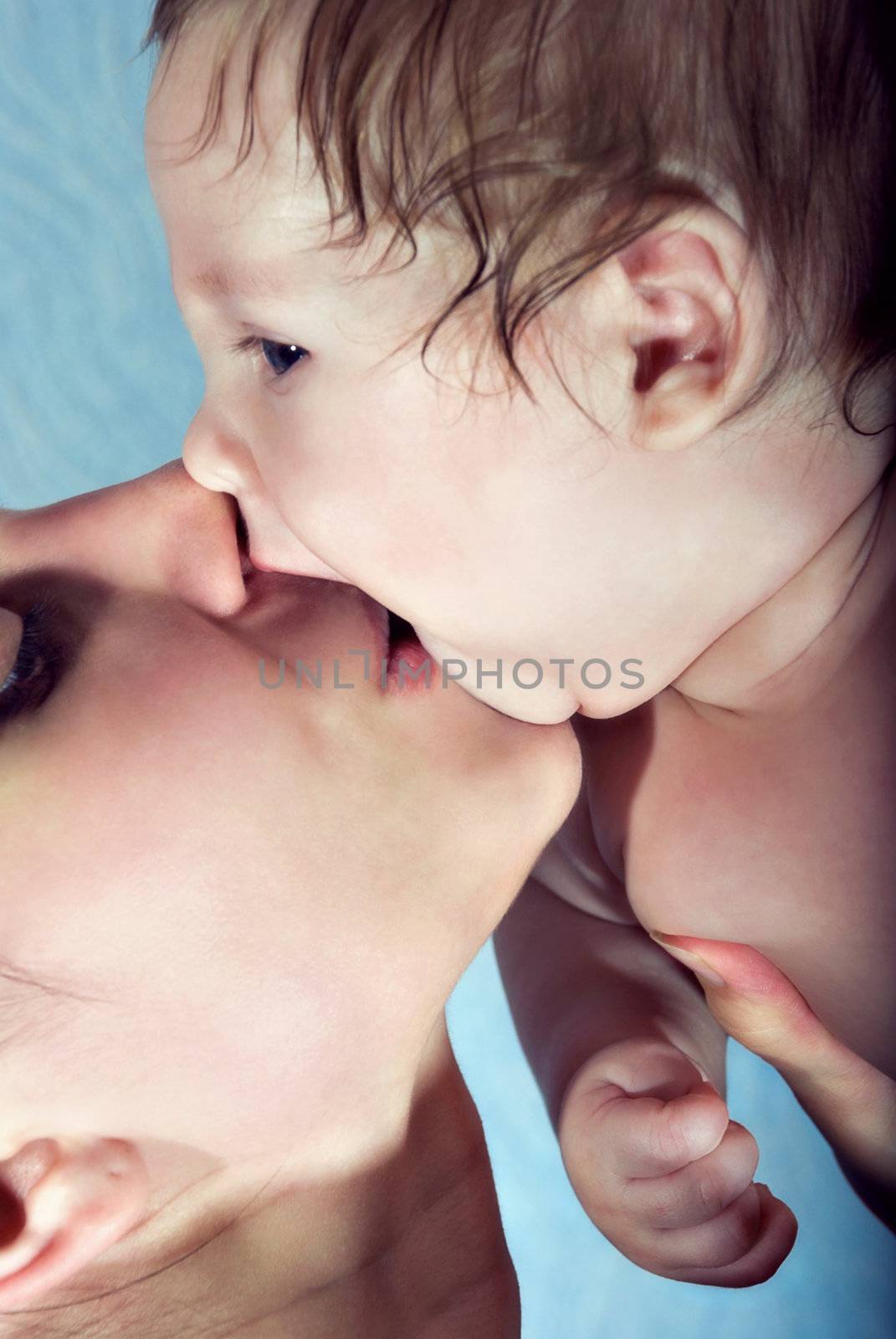 Beautiful baby kissing his mother by negativ