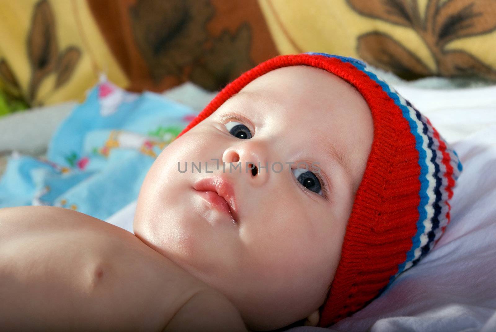 Closeup portrait of beautiful baby face on bed.