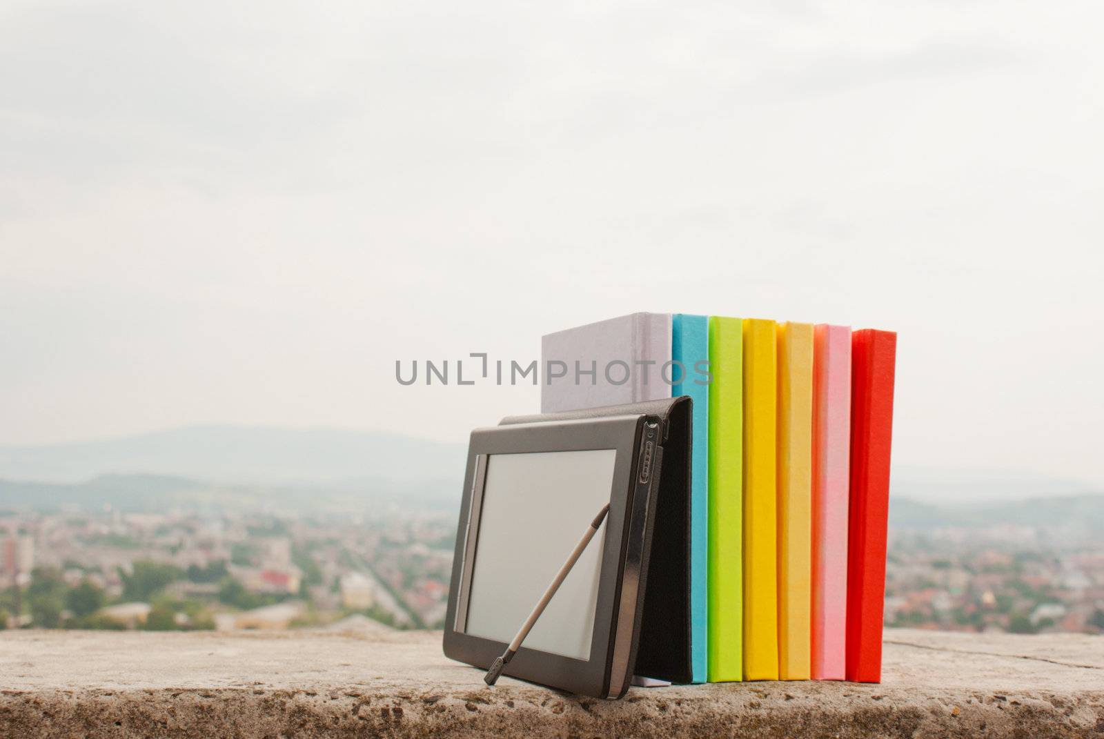 Row of colorful books with electronic book reader