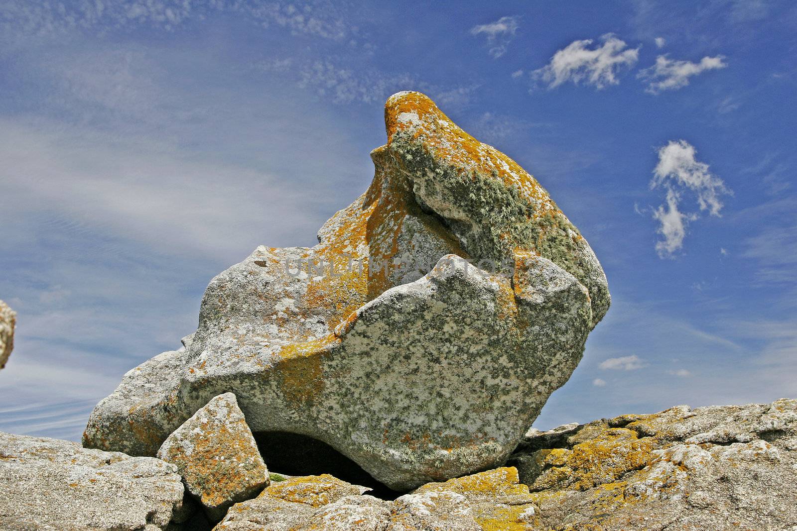 Rocks on the stone coast near Pointe de Trevignon, Brittany, North France. Stone with orange lichens.