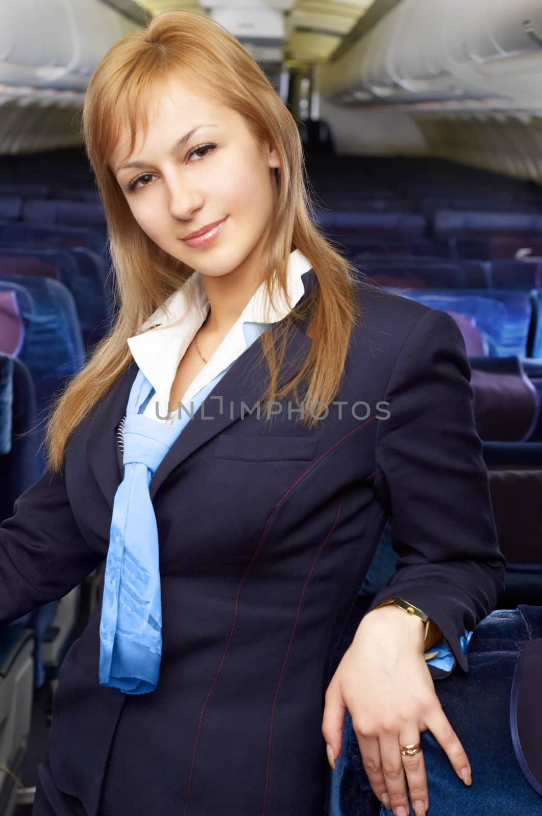 blond air hostess (stewardess) in the empty airliner cabin