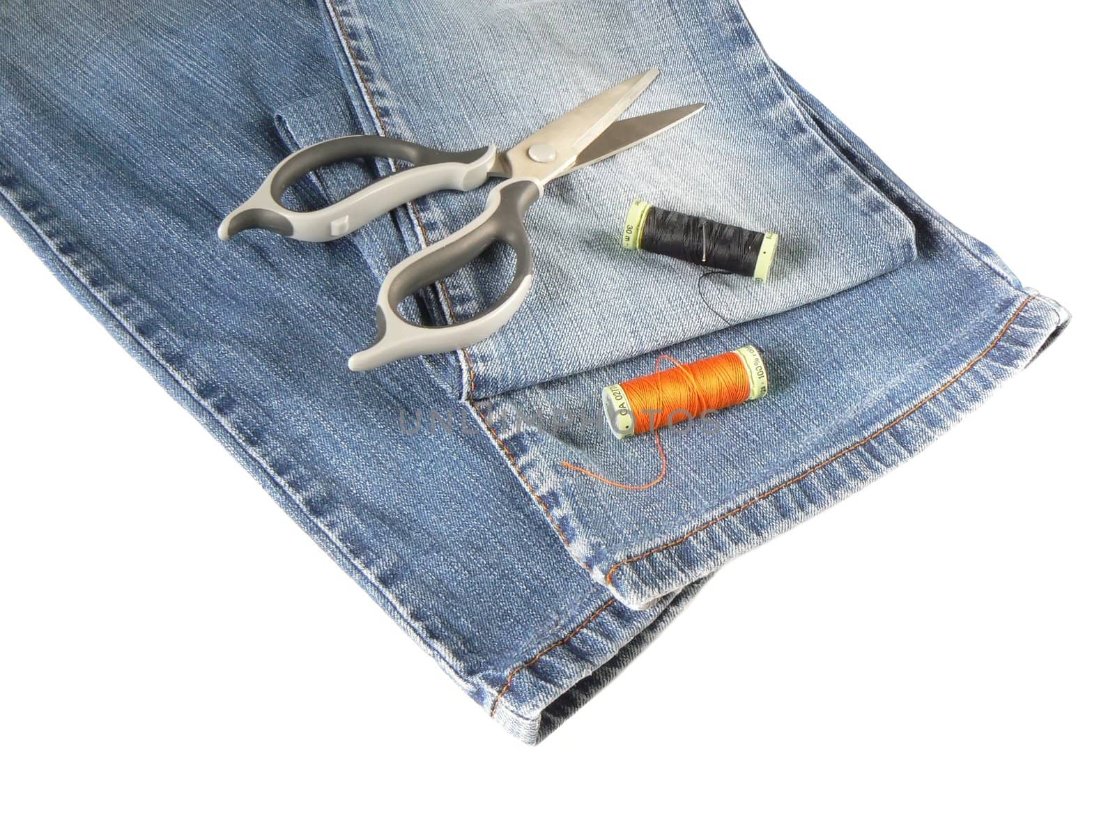 sewing accessorys and jeans on white background