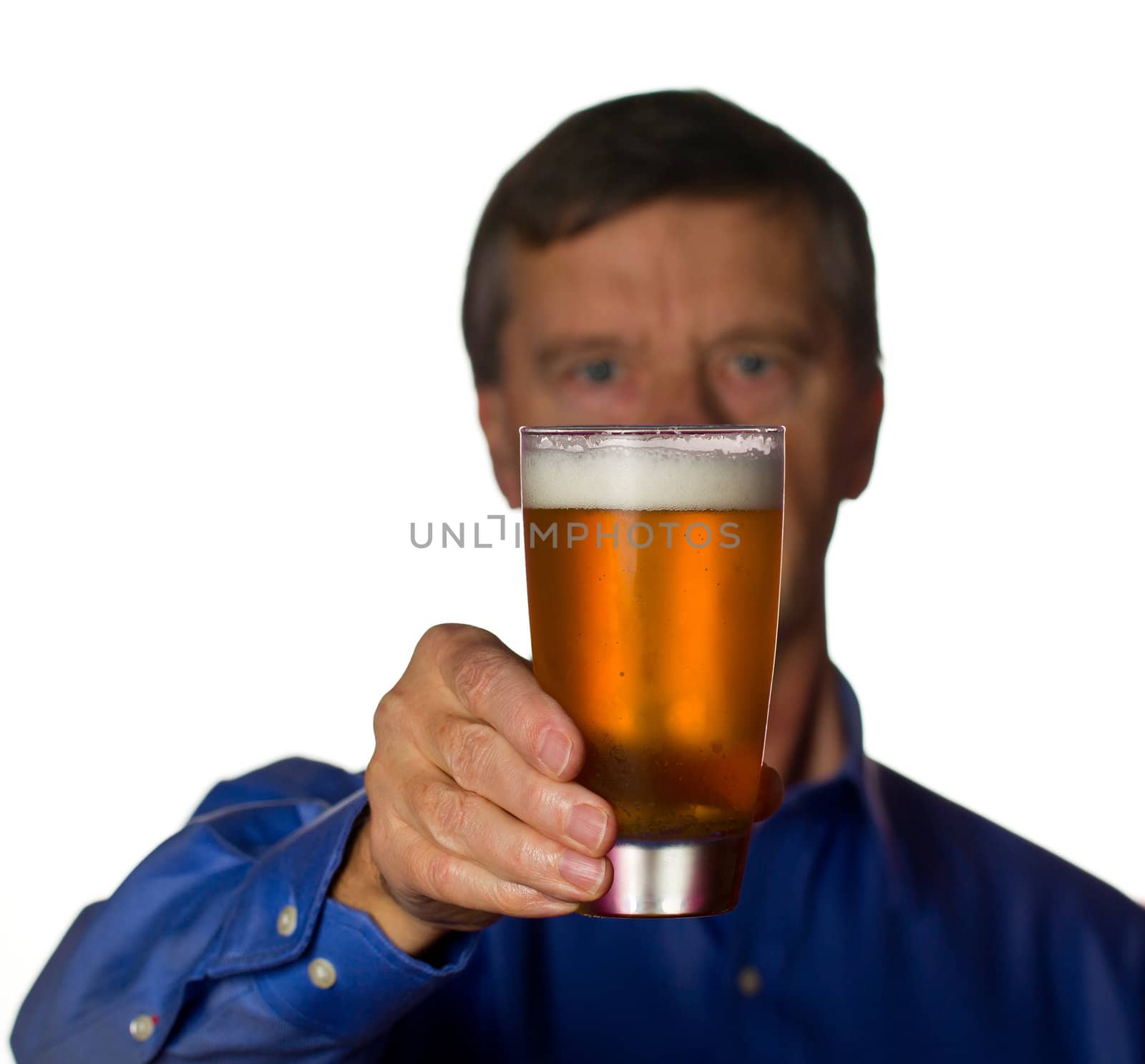 Senior retired male with a cool glass of beer with the man out of focus