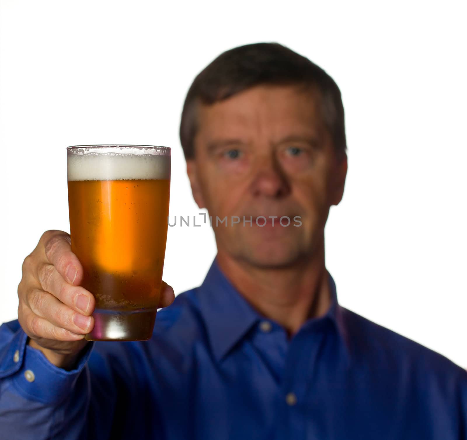 Senior retired male with a cool glass of beer with the man out of focus