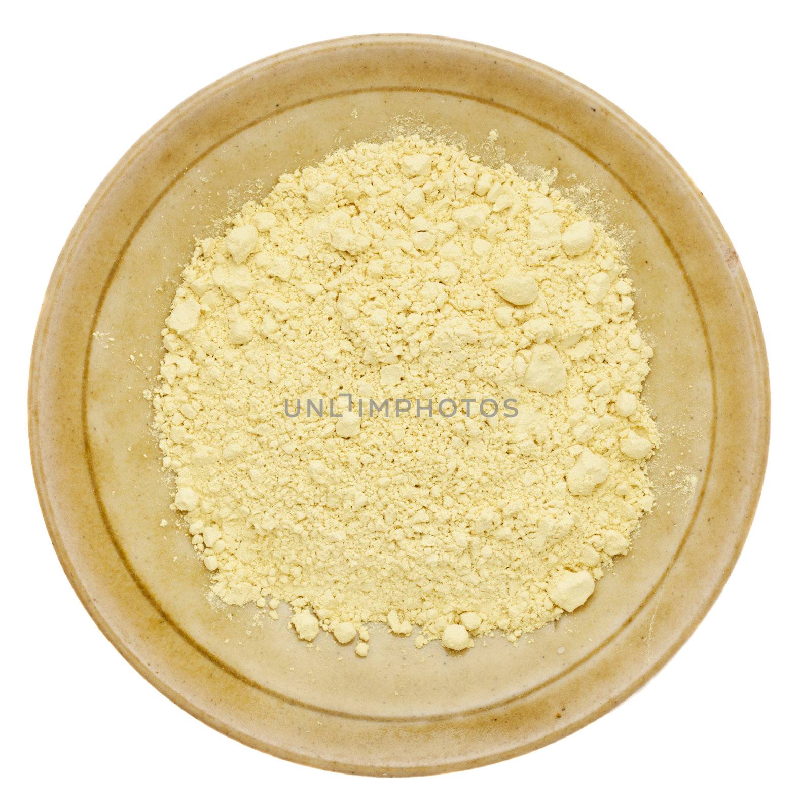 pine pollen powder (nutrition supplement) on a isolated small ceramic bowl