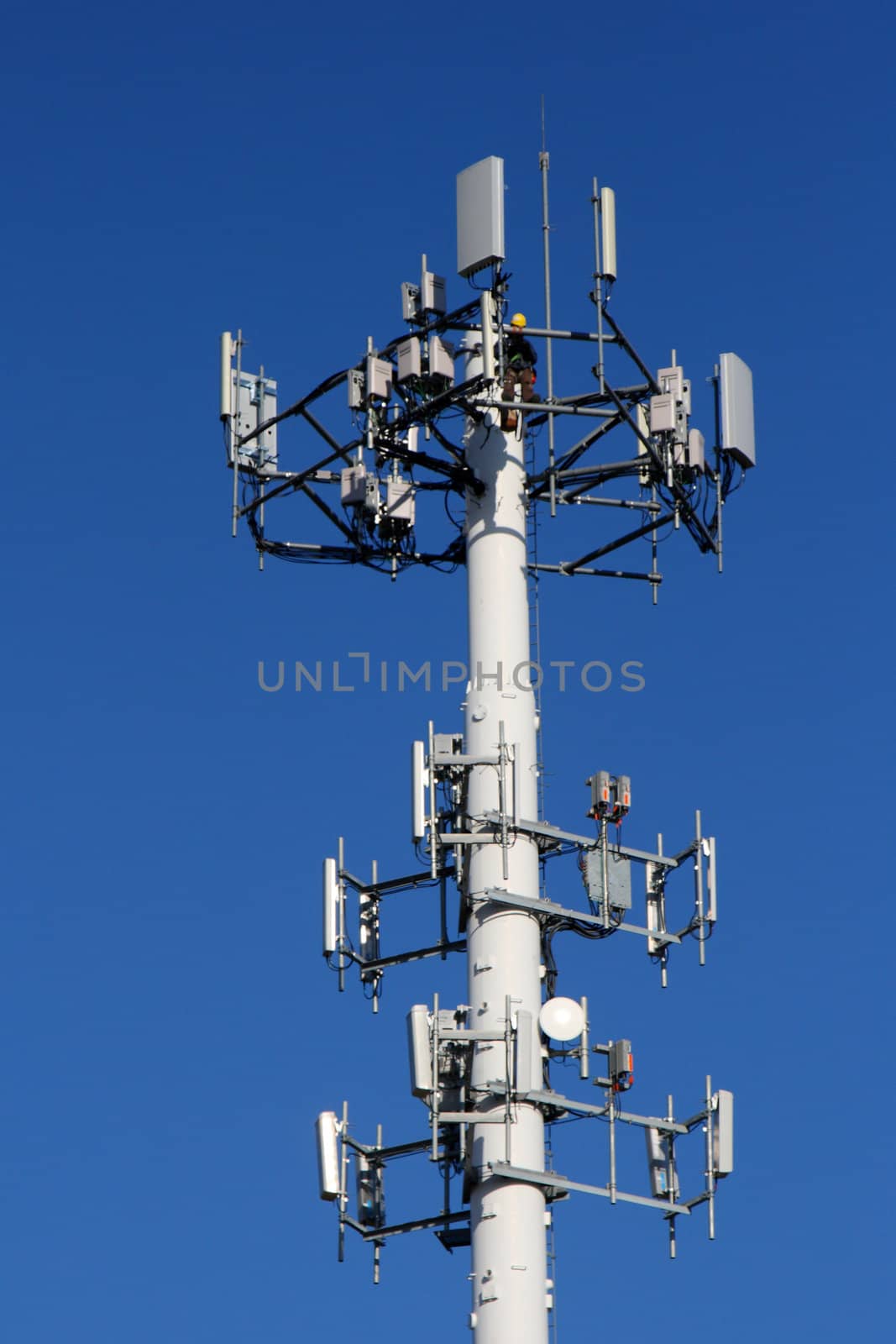 worker repairing communications tower by njene