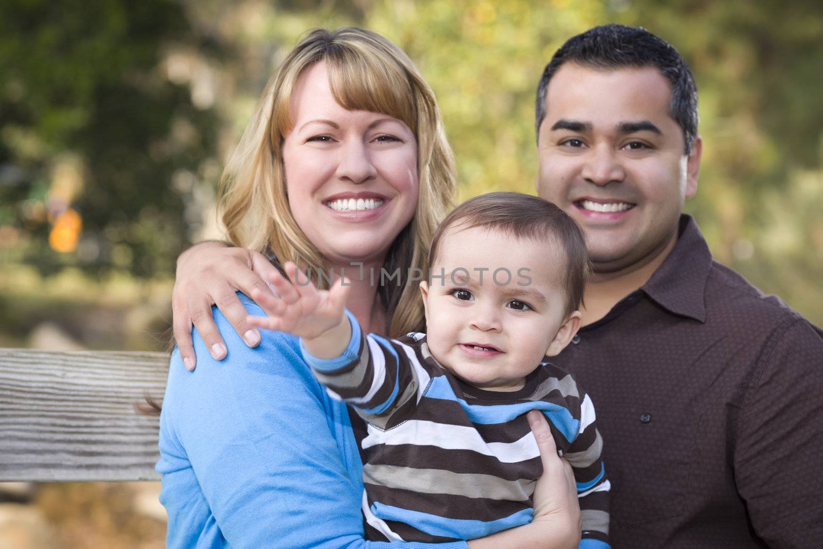 Happy Mixed Race Ethnic Family Posing for A Portrait in the Park.