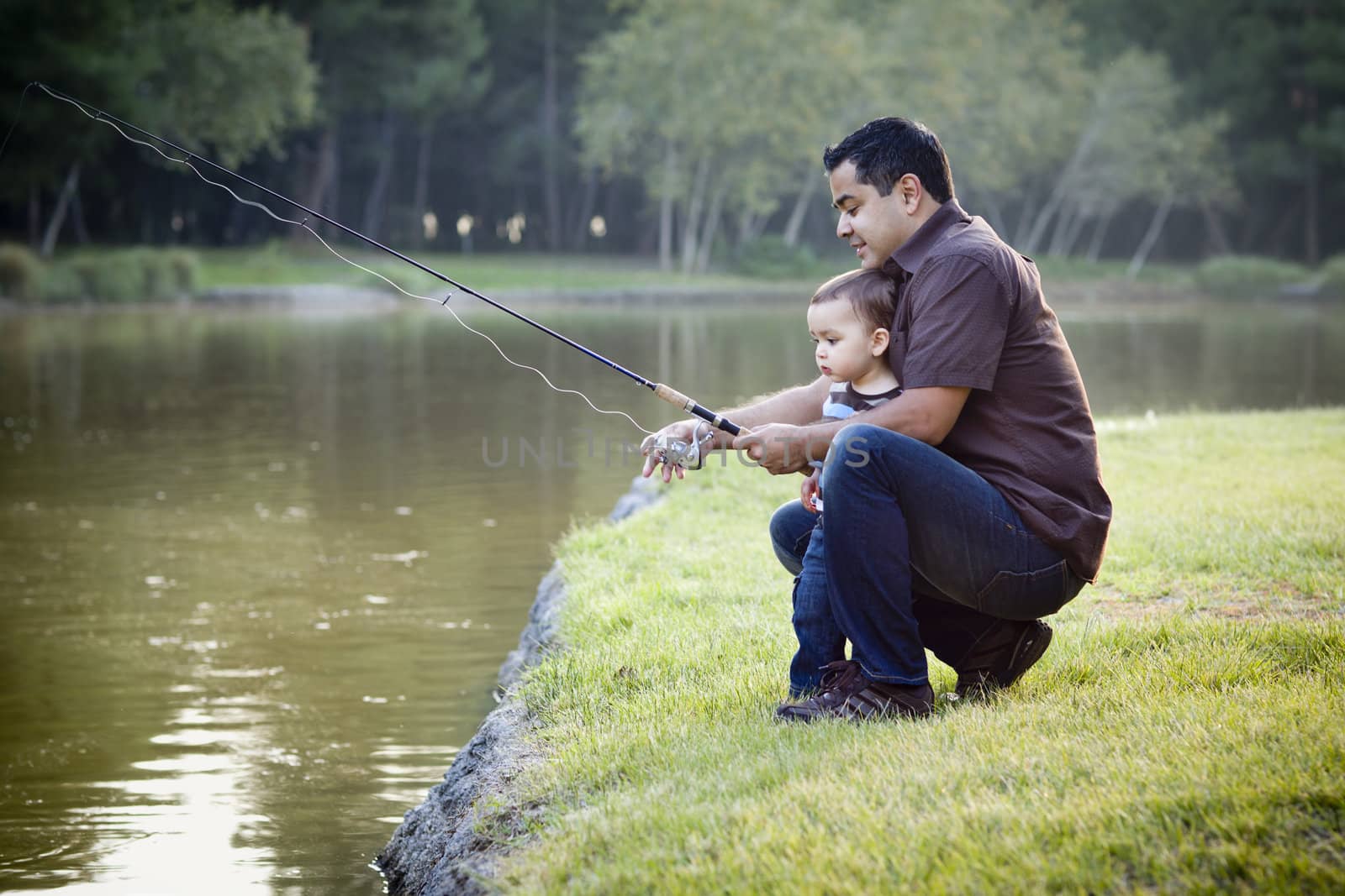 Happy Young Ethnic Father and Son Fishing at the Lake.