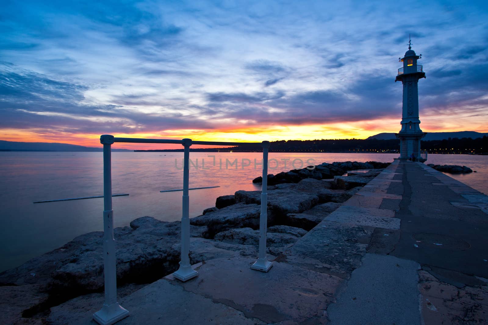 Lake Geneva lighthouse with colourful sunrise in background