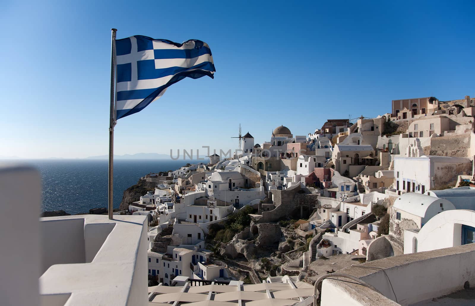 Greece national flag in Oia at Santorini over blue sky