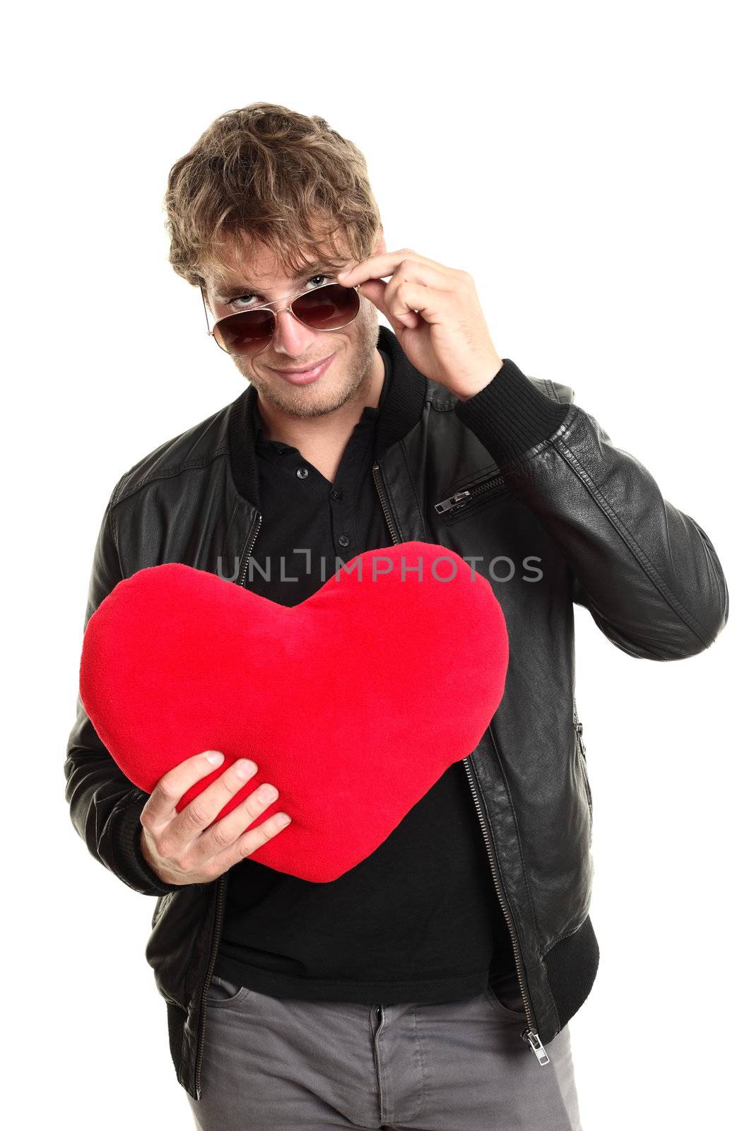 Valentines day man player holding heart looking over sunglasses. Funny image of caucasian male in leather jacket isolated on white background.