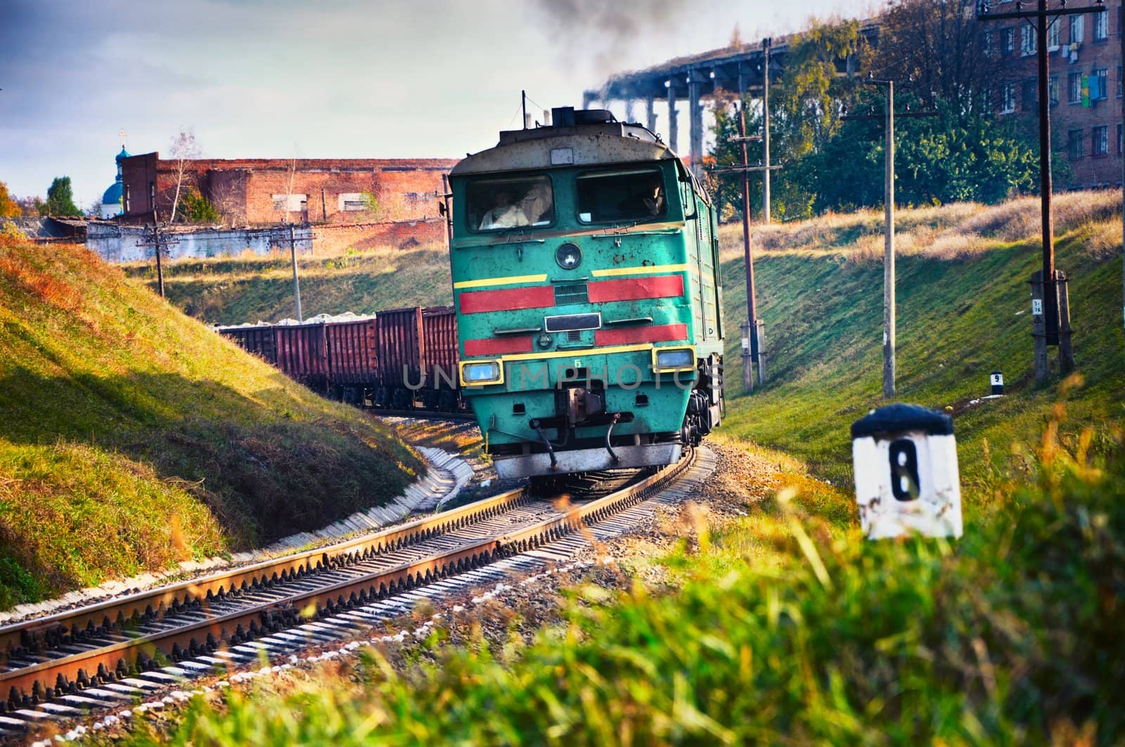 The diesel train with wagon goes on a curve. Cargo transportation in tanks by rail