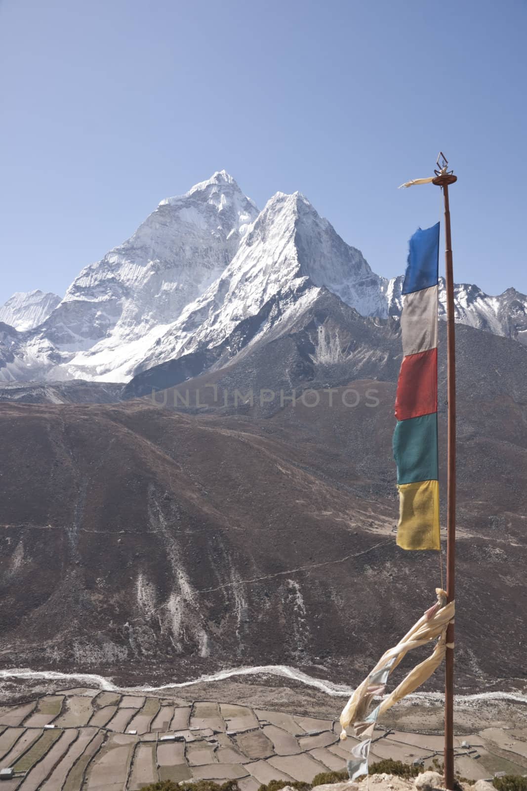 Prayer flags on a ridge overlooking the fields and village of Dingboche (4410 Metres) on the trekking route to Everest Base Camp, Nepal