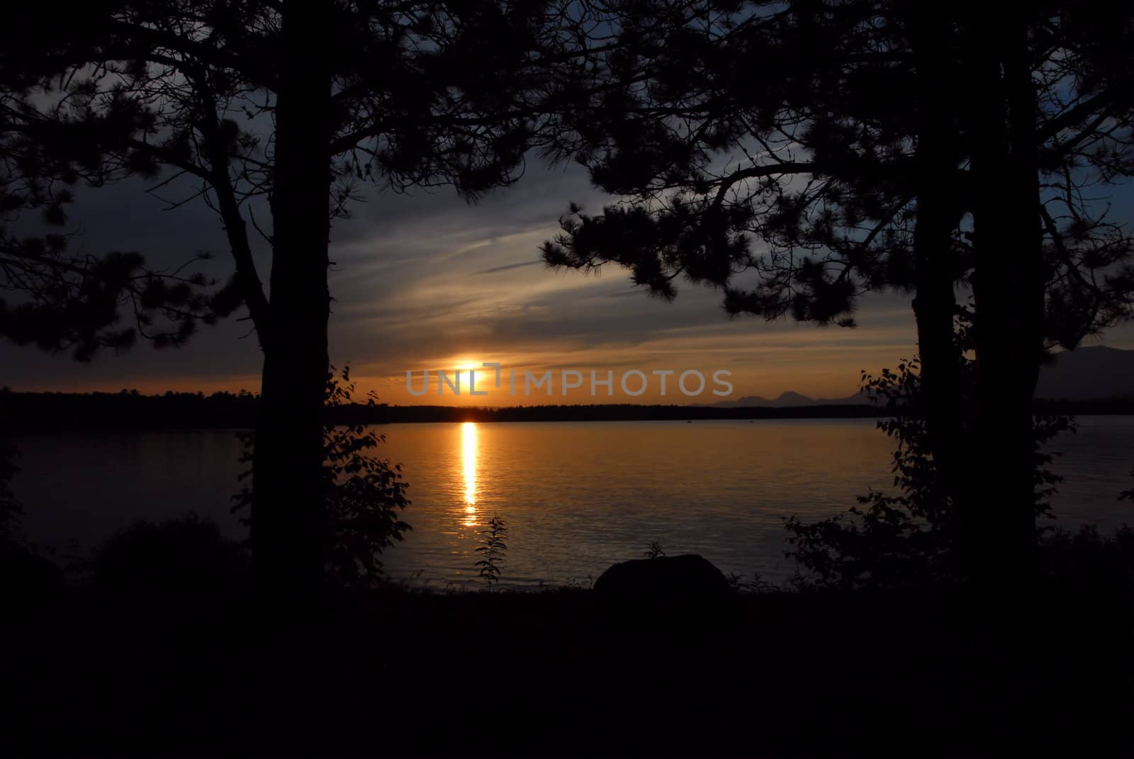 Sunset over Lake Millinocket in Maine. Framed by two trees