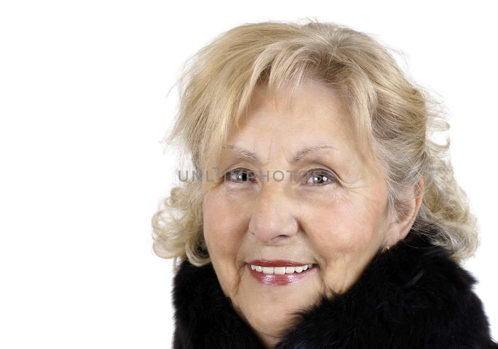 Portrait of a happy friendly senior woman smiling looking at camera and wearing a black fur collar for the cold winter day.
