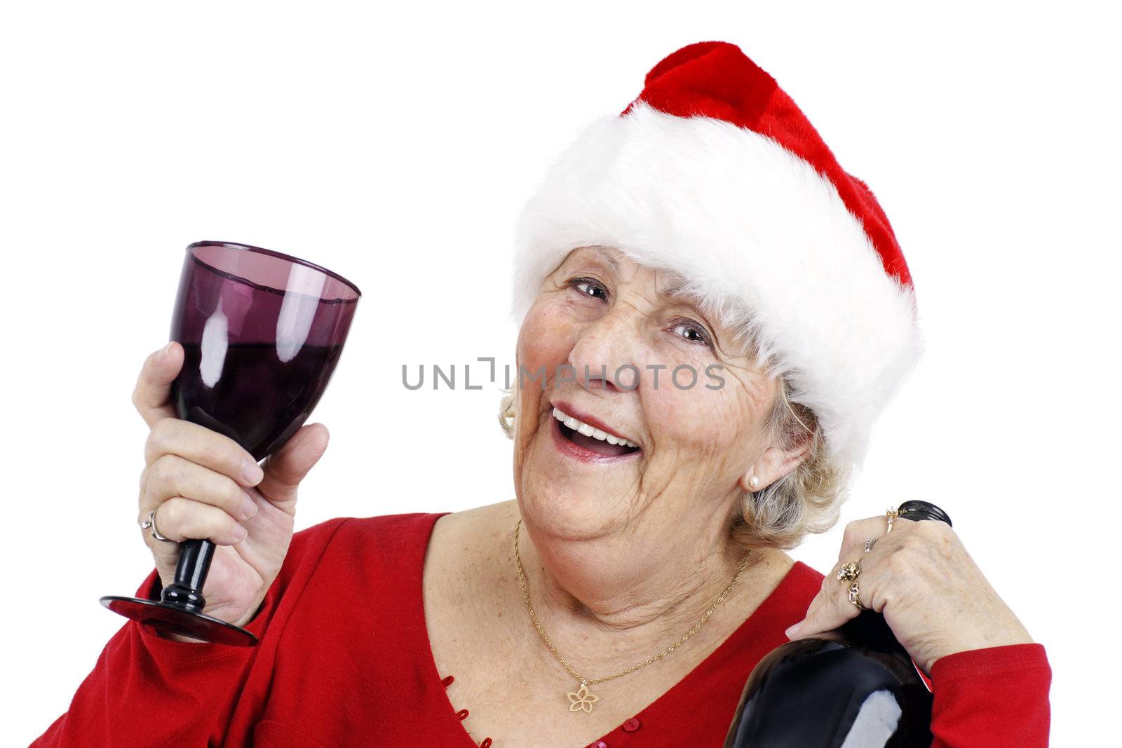 Holiday concept: Grandma is having a swell time at the Christmas party drinking alcohol or wine and raising her glass to make a toast.