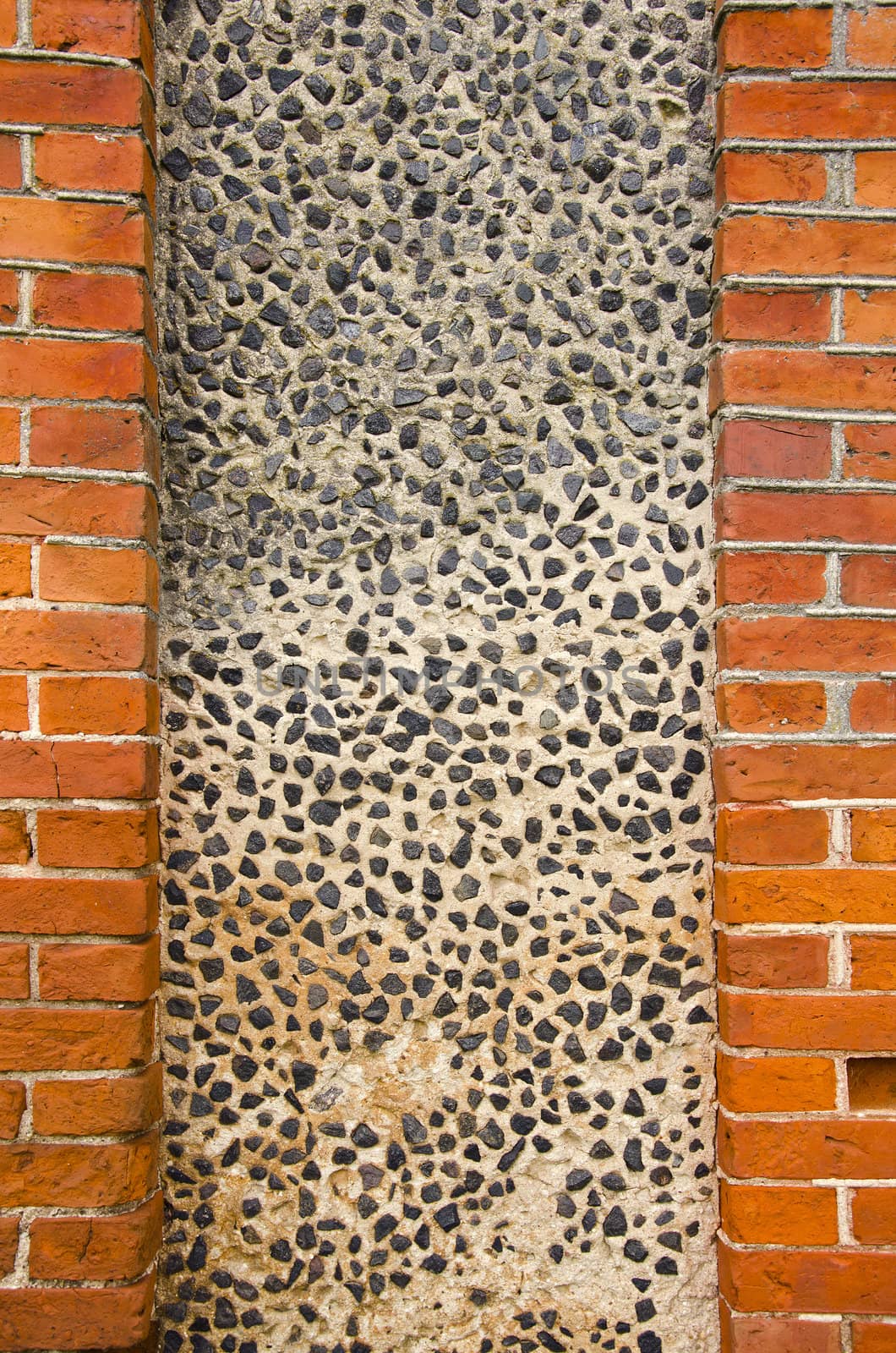 Wall made of brick and concrete with little stones by sauletas