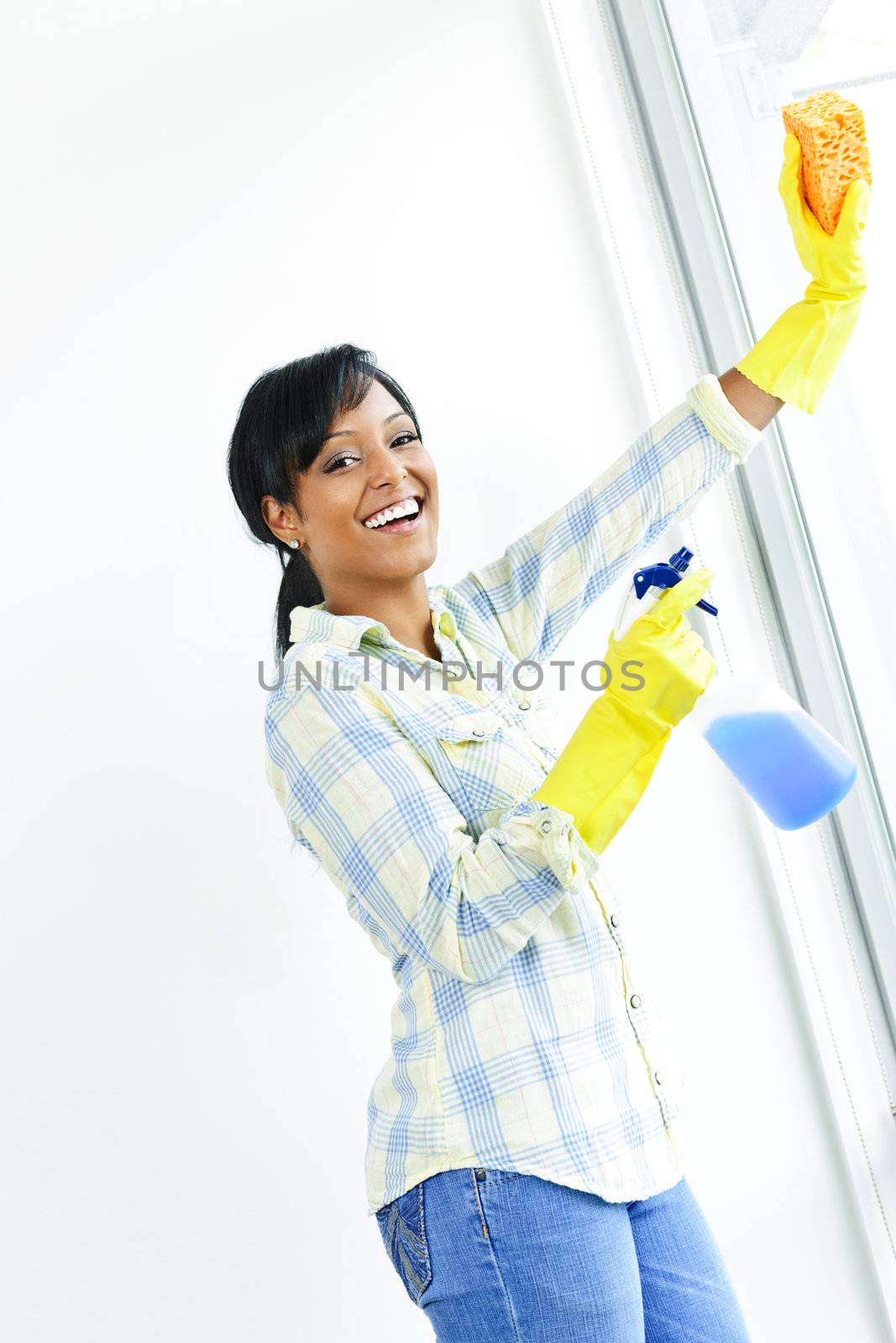 Smiling woman cleaning windows by elenathewise