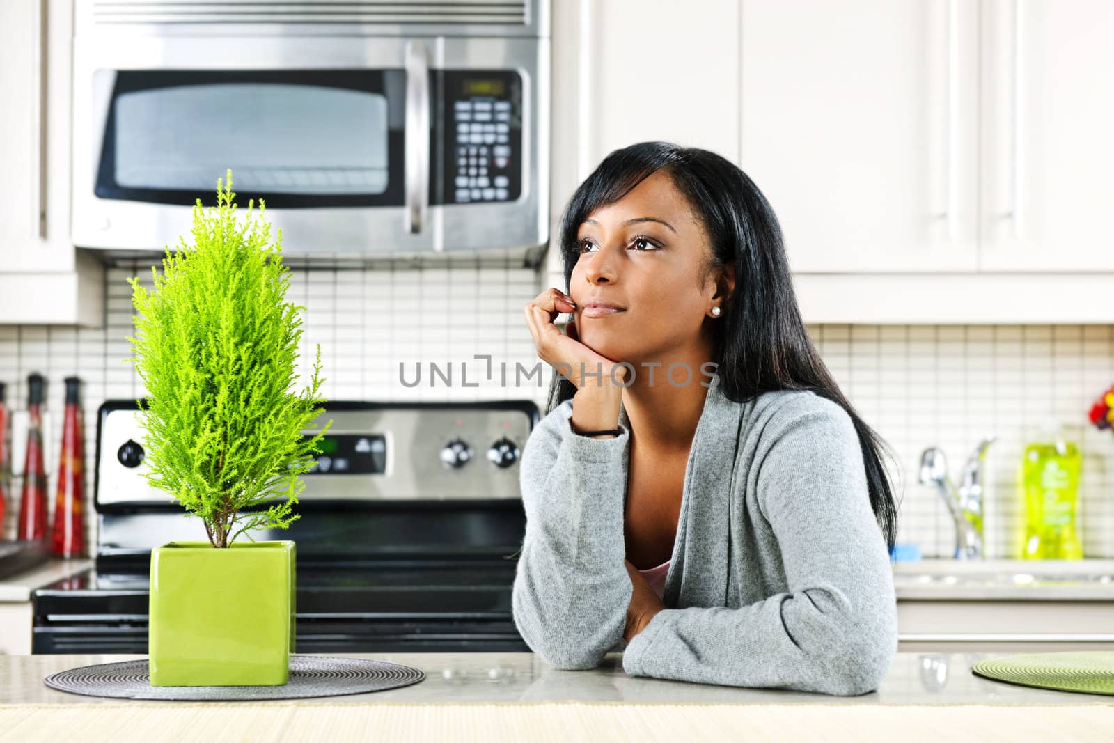 Thoughtful black woman in modern kitchen interior