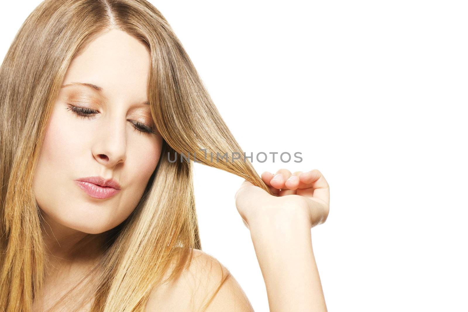 impishly blonde woman playing with her hairs on white background