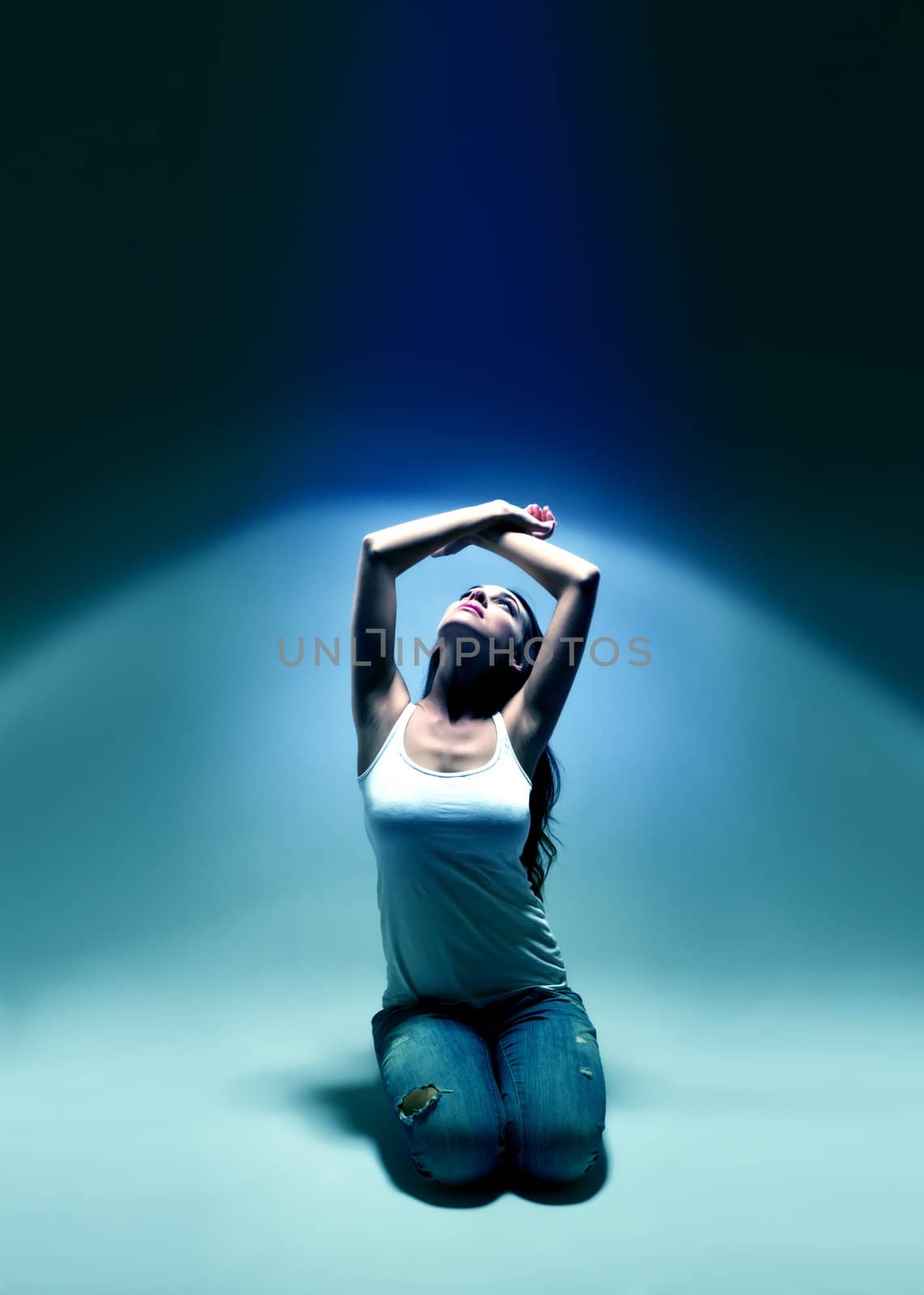 young woman looking upwards into blue spotlight atmosphere