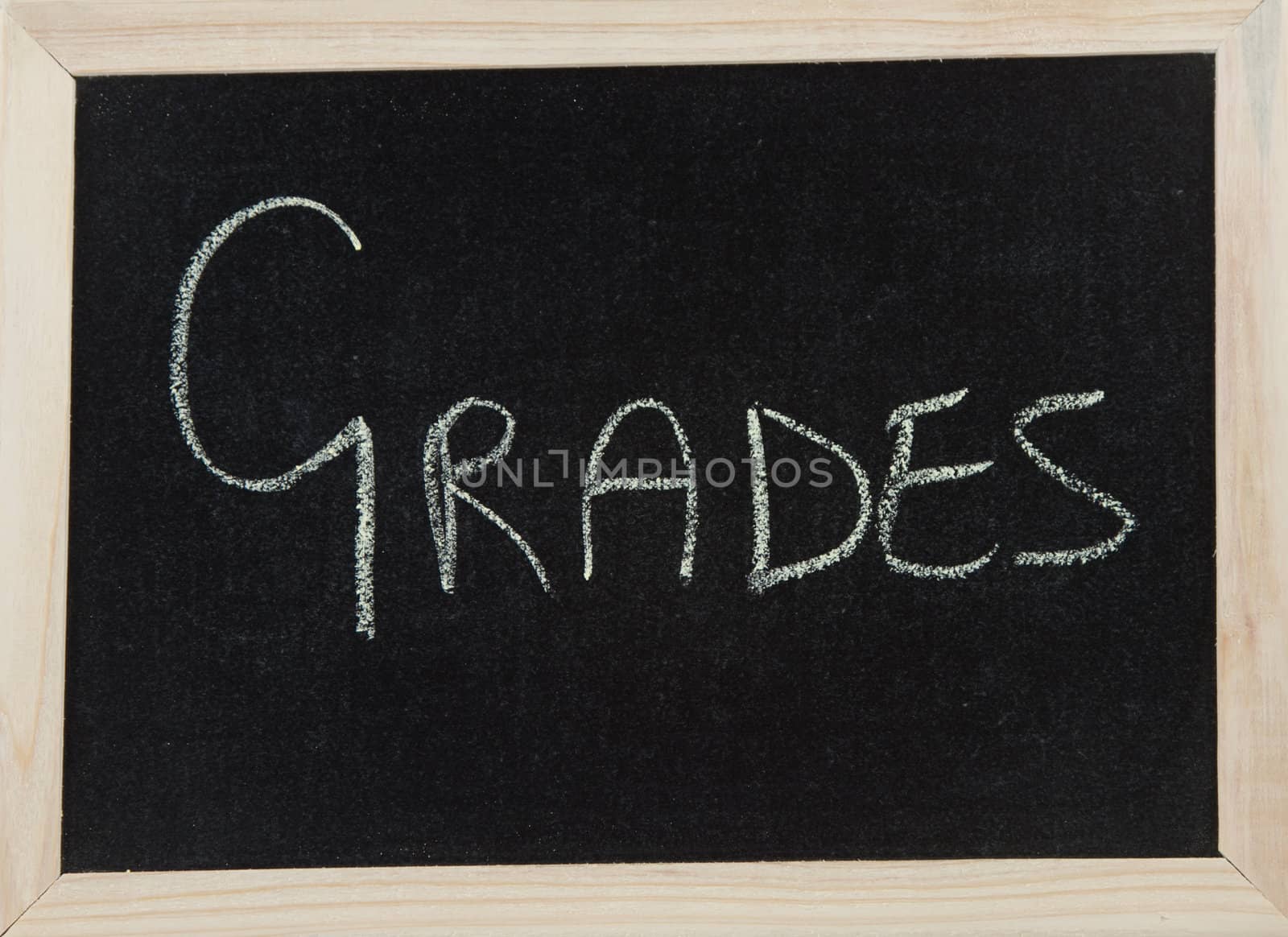 A black board with a wooden frame and the word 'GRADES' written in chalk.