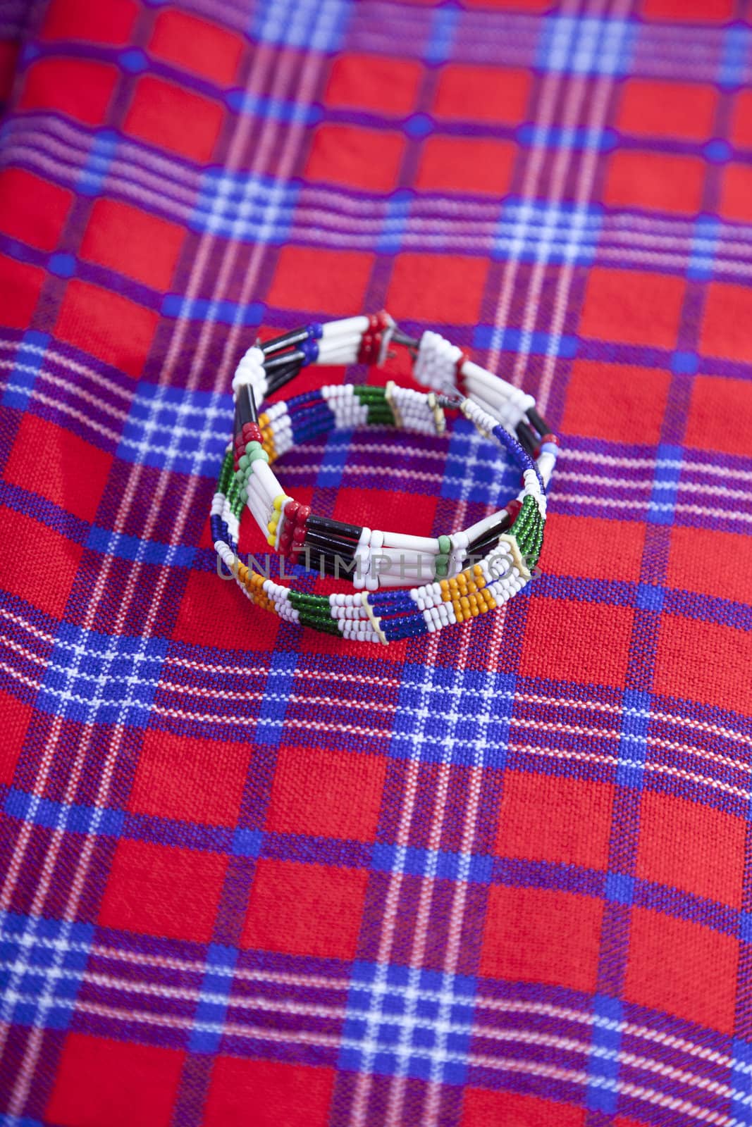 Colorful African bracelet with Masai blanket background