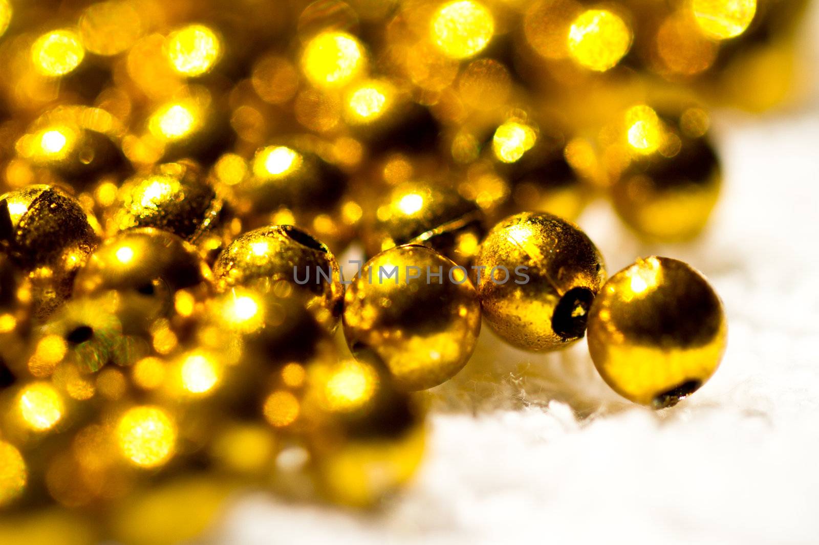Golden plastic beads with holes on white towel