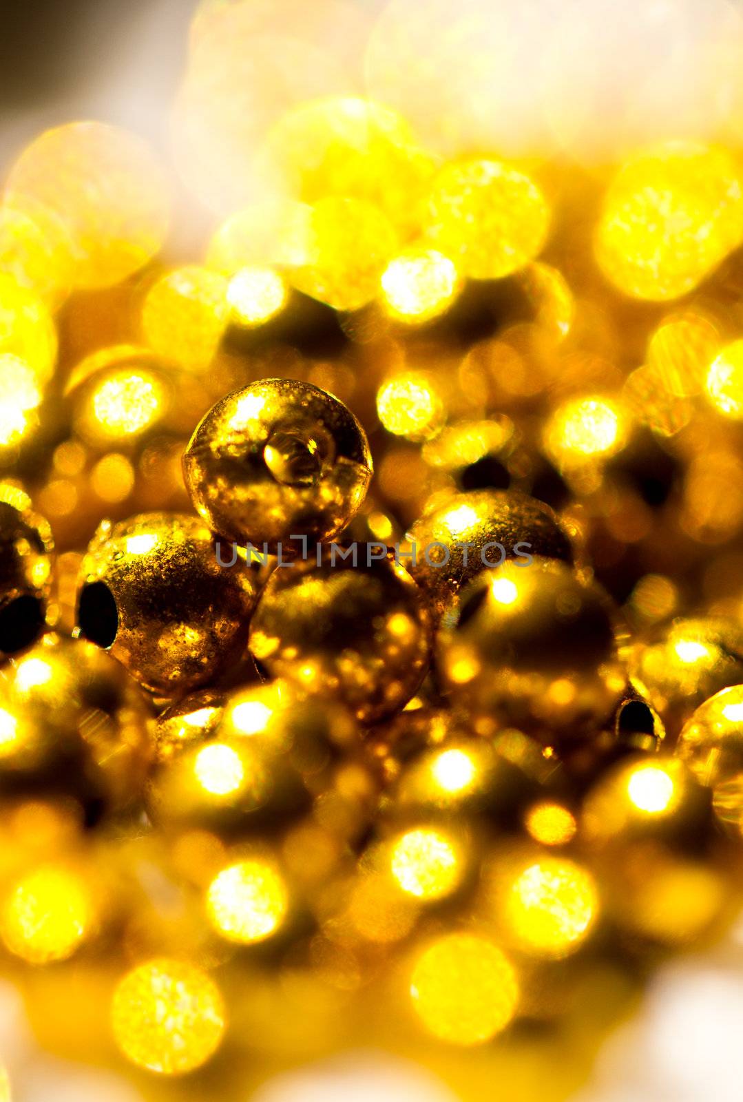 Golden colored beads shines under the sun can be use as background
