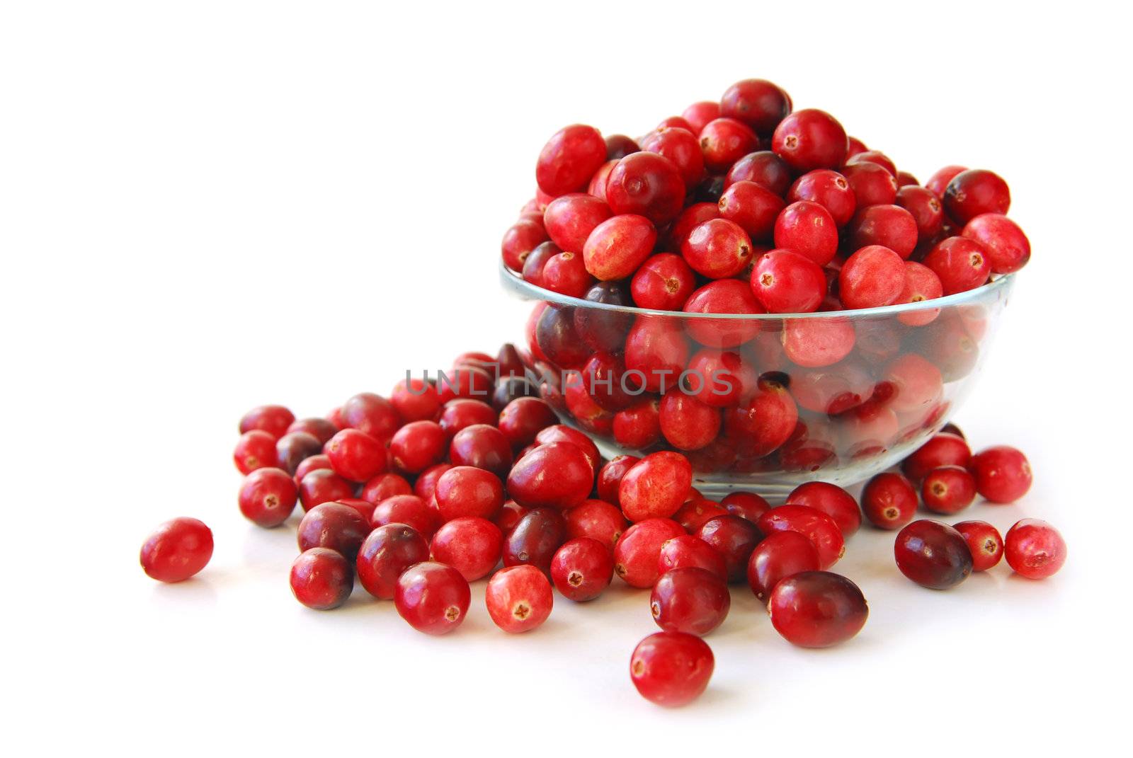 Fresh red cranberries in a glass bowl on white background