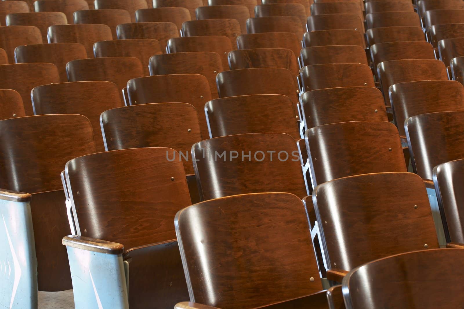 rows of wood chairs in an old auditorium