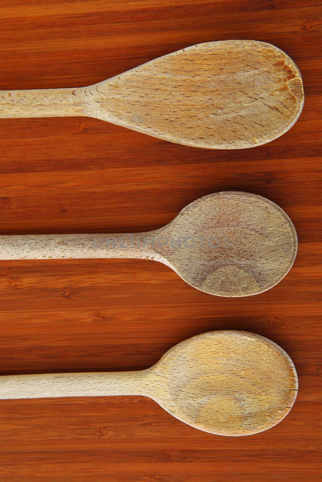 Old wooden cooking spoons on a cutting board in a kitchen