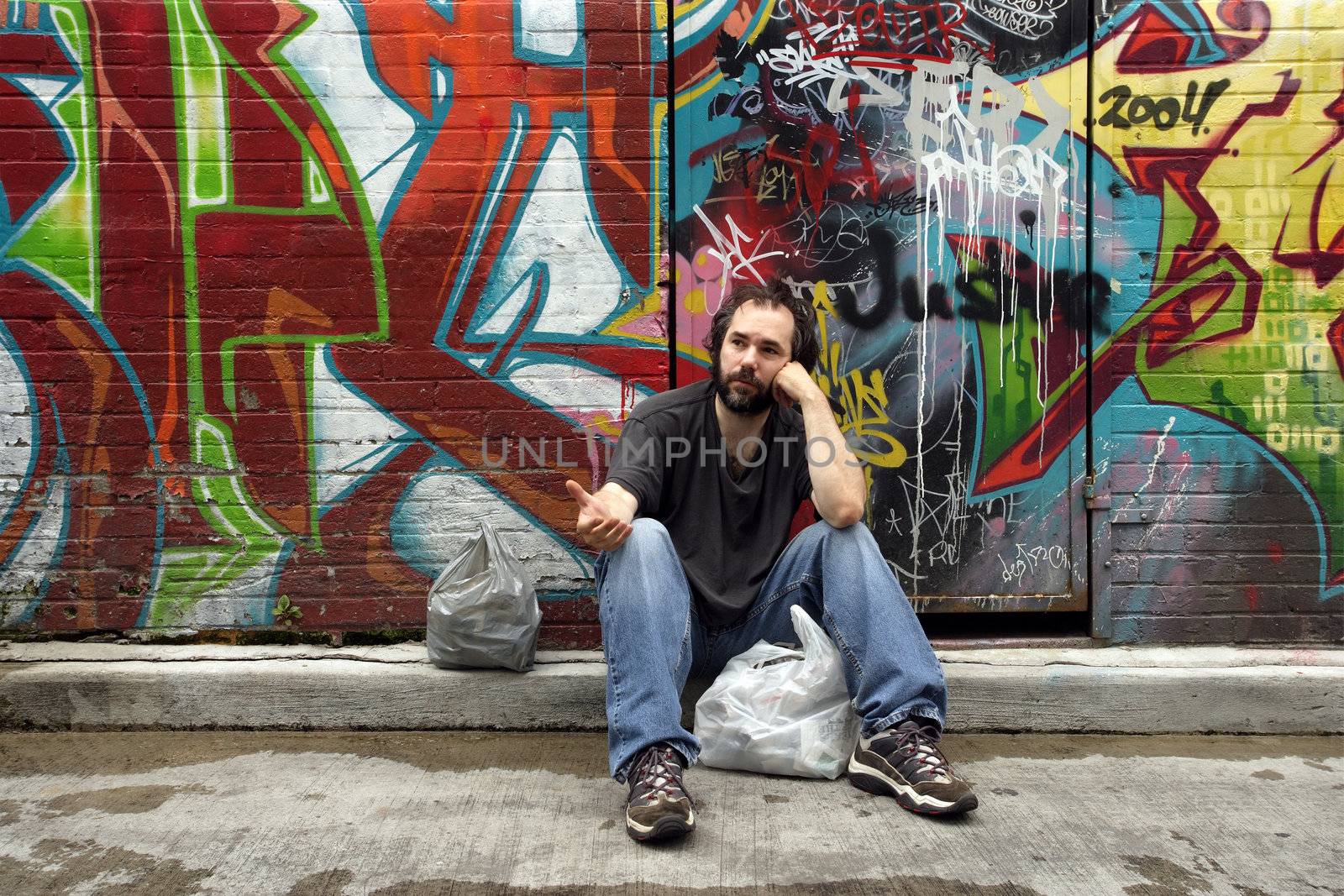 A homeless man begging on the city street.
