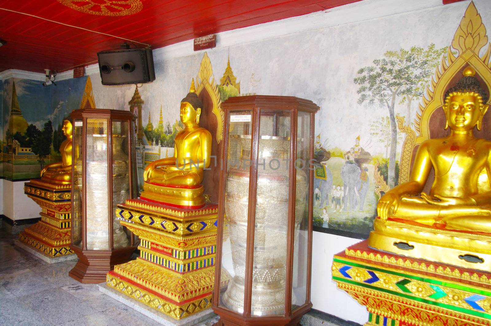 Dans un hall du temple de Wat Phrathat Doi Suthep à Chiang Mai au nord-ouest de la Thaïlande , des bouddhas et des jarres en argent fermées dans des chasses vitrées .
Les milliers de fidèles qui viennent journellement visiter le temple , laissent des sommes importantes d’argent . Le temple est extrêmement  riche au popint que d’autres temples moins fréquentés de la région déposent des urnes pour profiter de cette manne financière .