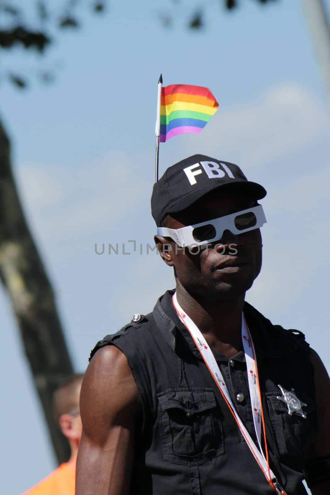 Black man wearing a cap with a rainbow flag on it while taking part in Gay Pride Parade 2011, Geneva, Switzerland