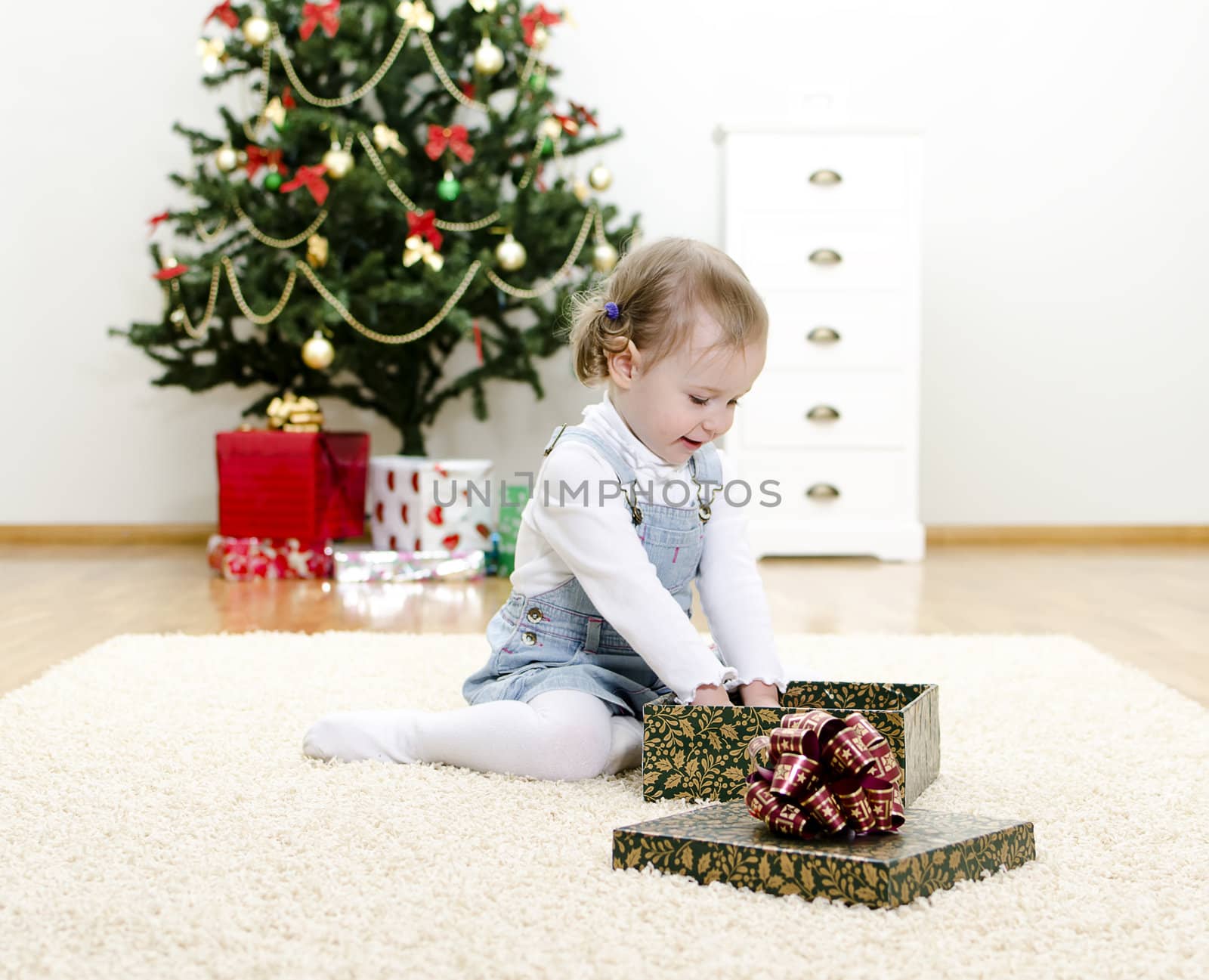 little girl unpacks the gift at Christmas