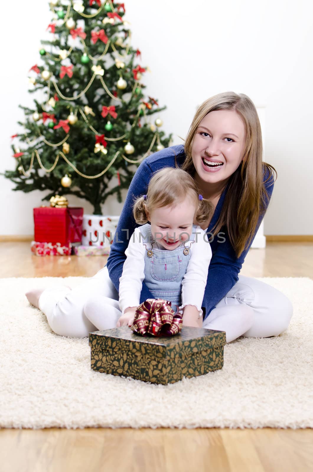 little girl and her mother unpacks the gift at Christmas